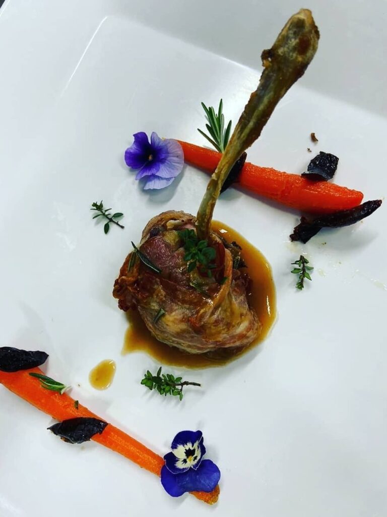 il carré di agnello farcito con crema di cipolla rossa di Tropea e caprino avvolto in manto di pancetta e accompagnato con carote in agrodolce con aceto di mele e prugna secca